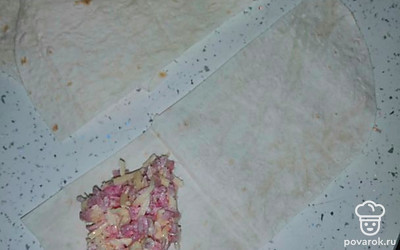 Положить на каждую полоску ложку начинки.