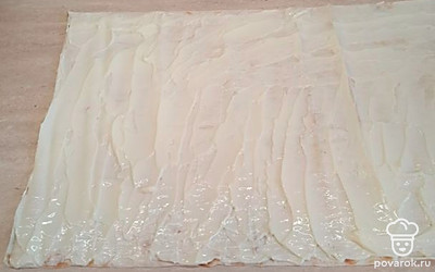 Разложите лаваш. Я его разрезаю пополам, чтобы получилось два рулета. Смажьте лаваш плавленым сыром. 