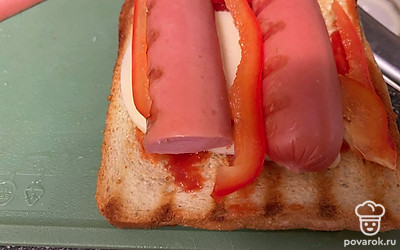 Выложите сыр, сосиску и перец.