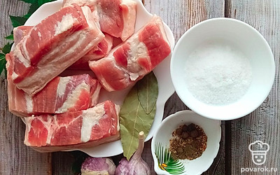 Сало разрезаем на небольшие кусочки шириной 5 сантиметров и длиной 10-15 сантиметров. Чеснок чистим и режем дольками. 