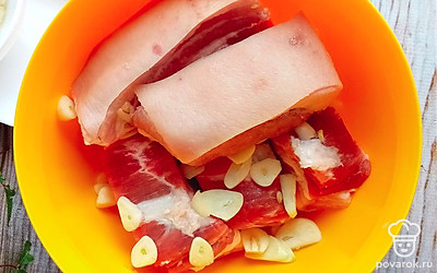 В чашку выкладываем слоями чеснок и сало до полного заполнения. 