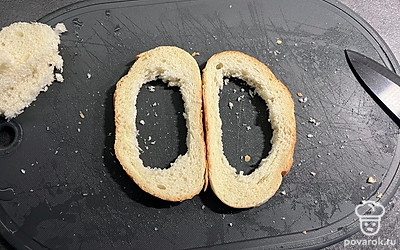 Вырезаем в ломтиках хлеба отверстия.