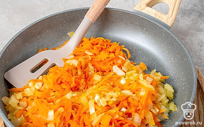 Мелко покрошите репчатый лук, а морковь натрите на терке. Разогрейте на сковороде растительное масло. Обжарьте лук с морковкой в течение 5 минут на среднем огне, регулярно перемешивая овощи.