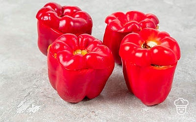 Срежьте верхнюю часть у перцев, это будут «крышечки». Удалите семенные коробочки. Плотно уложите начинку в каждый перец, а затем закройте «крышечкой».