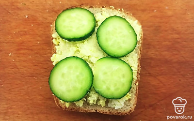 Намажьте получившуюся смесь на хлеб и выложите тонкие ломтики огурца.