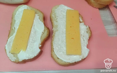 Два ломтика хлеба смазываем сметаной и сверху кладем по кусочку сыра. 