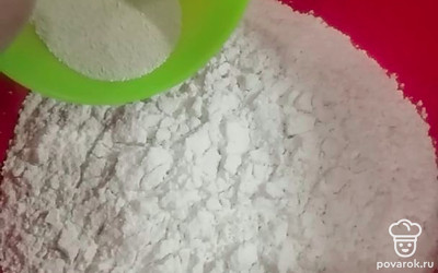 В глубокую миску просеиваем муку. К муке добавляем сухие дрожжи. 