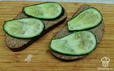 Выложить сверху по два тонких ломтиками огурца. 