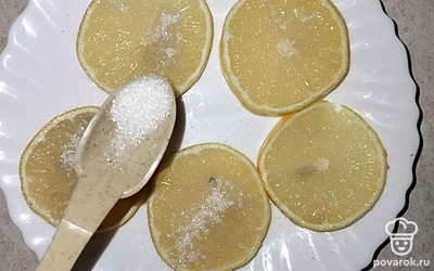 Выкладываем кружочки лимона на тарелку и посыпаем сахаром (примерно половина чайной ложки).