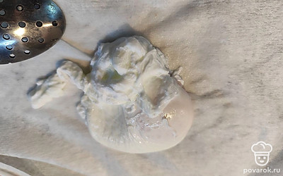 Аккуратно и быстро влить яйцо в образовавшуюся воронку. Можно продолжать при этом помешивать воду по кругу, чтобы яйцо не расплылось по воде, а собралось в один клубочек. Варить 2 минуты, достать шумовкой или ложечкой и переложить на салфетку или полотенце.