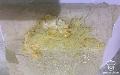 Сверху выложите тертый сыр. Пока яйцо горячее, сыр будет плавиться.