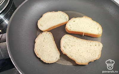 Батон обжарить на сухой сковороде. В это время натереть сыр на мелкой терке. 
Вяленые томаты нарезать мелкими кусочками. Чеснок — мелкими кубиками. 