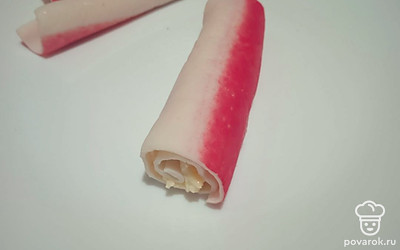 Сверните крабовые палочки в рулеты.