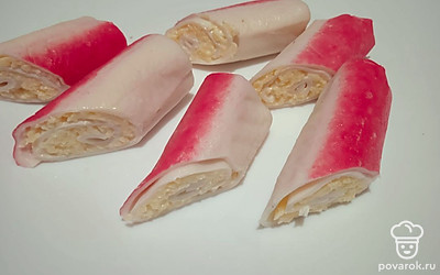 Разрежьте каждый крабовый рулетик на две части наискосок.