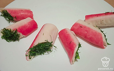 Укроп нарежьте. Обмакните рулетики косым срезом в нарезанный укроп.