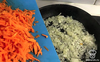 К слегка протушенному луку добавить тертую морковь.
