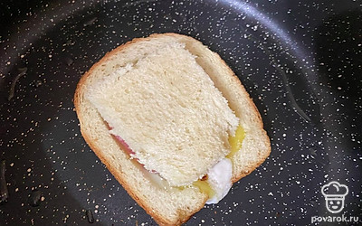 Когда снизу яйцо немного пожарилось, через 1-2 минуты, положите мякиш сверху. Так жарьте еще 1-2 минуты.