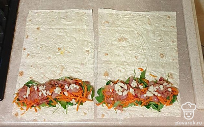 Поверх салатный листьев выложите морковь по-корейски, мелко нарезанный сыр и обжаренный бекон.