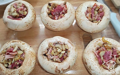 Грибы сложить в форму для запекания. Начинить грибы смесью с беконом.