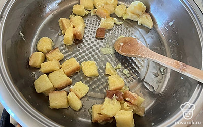 Как только яйцо начнет схватываться, начните ломтики хлеба активно перемешивать лопаткой. 