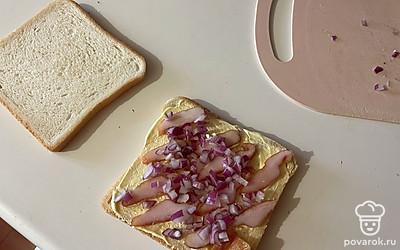 Поверх грудки выложите нарезанный лук. 