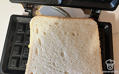 Выложите тост с начинкой на разогретую вафельницу. 