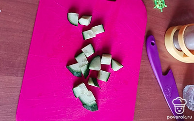 Нарежьте огурец небольшими квадратиками.