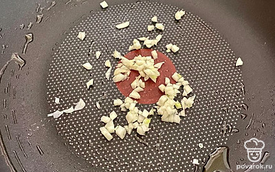 Зубчики чеснока очищаем от шелухи и мелко нарезаем. Сковороду смазываем оливковым маслом, выкладываем чеснок. Обжариваем на среднем огне в течение 3 минут.