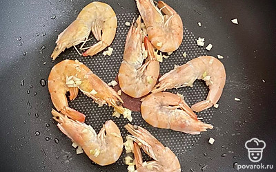 Добавляем к чесноку креветки и обжариваем в течение 3 минут на среднем огне.