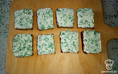 Намажьте творожный сыр с петрушкой на квадратики бородинского хлеба.