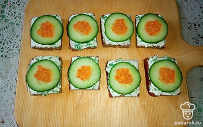 Положите в центр каждого кружочка огурца небольшое количество красной икры.