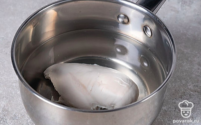 Вскипятите воду в кастрюле, а затем положите в нее куриное филе. Варите его примерно 20-25 минут до готовности на среднем огне, а затем остудите.