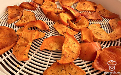 Сушилку включаем. Сушим при максимальный температуре два часа, затем переворачиваем дольки хурмы и сушим еще 30 минут до готовности.