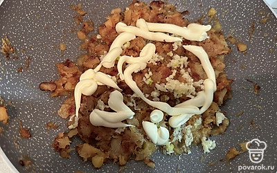 В жареный кабачок добавляем измельченный чеснок и майонез.