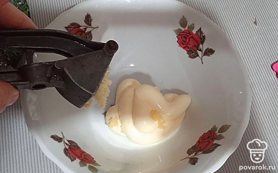 В тарелочку кладем майонез, выдавливаем чеснок.