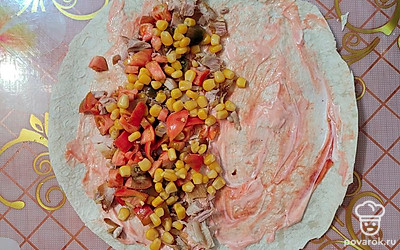 С кукурузы слить рассол, выложить следующим слоем на половинку лаваша.