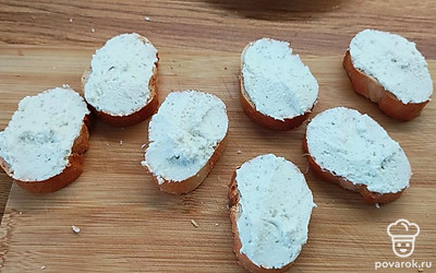 Багет нарезать порционными кусочками. Смазать его творожным сыром.
