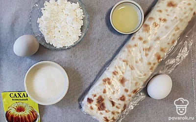 Подготовьте продукты. Нарежьте лаваш полосками по 8-10 сантиметров в ширину. Разогрейте сковородку. 1 яйцо взбейте.