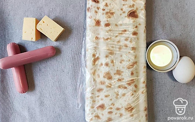 Подготавливаем продукты. Нарезаем лаваш полосками по 8-10 сантиметров в ширину. Разогреваем сковородку. Сыр нарезаем ломтиками.