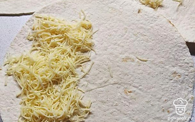 На половину каждой лепешки выложить немного сыра. 