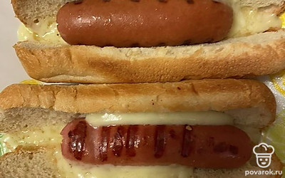 Сосиски зажарьте на гриле, вложите в булку. Добавьте кусочки сыра и поставьте в микроволновку, чтобы сыр расплавился.