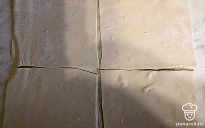 Пласты слоеного теста слегка раскатать и каждый пласт разрезать на 4 квадрата.