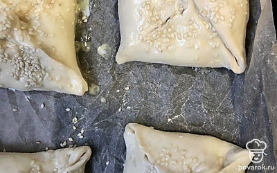 Выложить хачапури на пергамент, смазать яйцом, можно только желтком. Посыпать кунжутом и отправить в заранее разогретую духовку при 180 градусах на 25-30 минут.