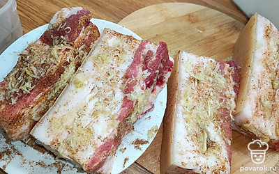 Измельченным чесноком натереть бруски сала.