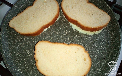 Нарежьте 4 кусочка белого хлеба. Выложите равномерно половину получившейся массы из творога, сахаа и яиц на кусочки хлеба. Сразу кладите обжариваться хлеб с творожной массой на разогретую сковороду с растительным маслом творогом вниз. Вторая половина творожной массы с сахаром и яйцами понадобится для другой стороны гренок, после обжаривания этой стороны.