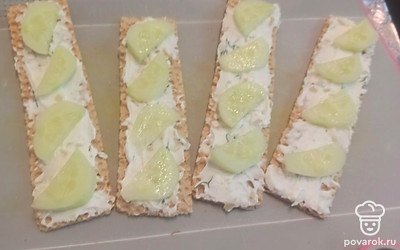 Чистим и нарезаем огурец, раскладываем поверх соуса. 