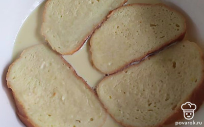 Смешать в миске молоко с яйцами и замочить в этой смеси ломтики белого хлеба. Перевернуть хлеб несколько раз, чтобы он хорошо пропитался. Чем больше пропитается хлеб, тем нежнее будут гренки. 