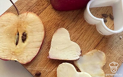 Из яблока с помощью формочек для печенья вырезаем сердечки.