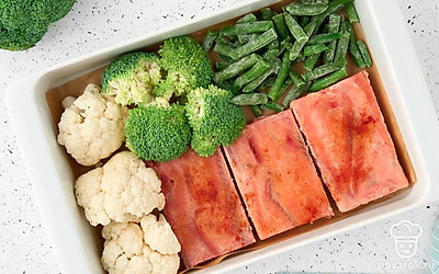 Когда рыба замаринуется, разогрейте духовку до 200 °C. Застелите форму для запекания пергаментной бумагой и разложите цветную капусту, брокколи, стручковую фасоль и горбушу.