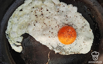 Отделите белок от желтка. Разогрейте сковороду с маслом. Вылейте на сковороду сначала белок, а затем желток. Добавьте соль, перец. 